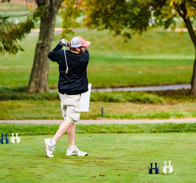 Man Swinging golf club, playing golf