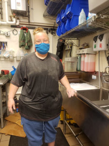 A woman at work in the back of a restaurant.