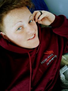 Penn Mar Employee, Emily Finnegan, Smiling in a Penn-Mar Hoodie Sweatshirt