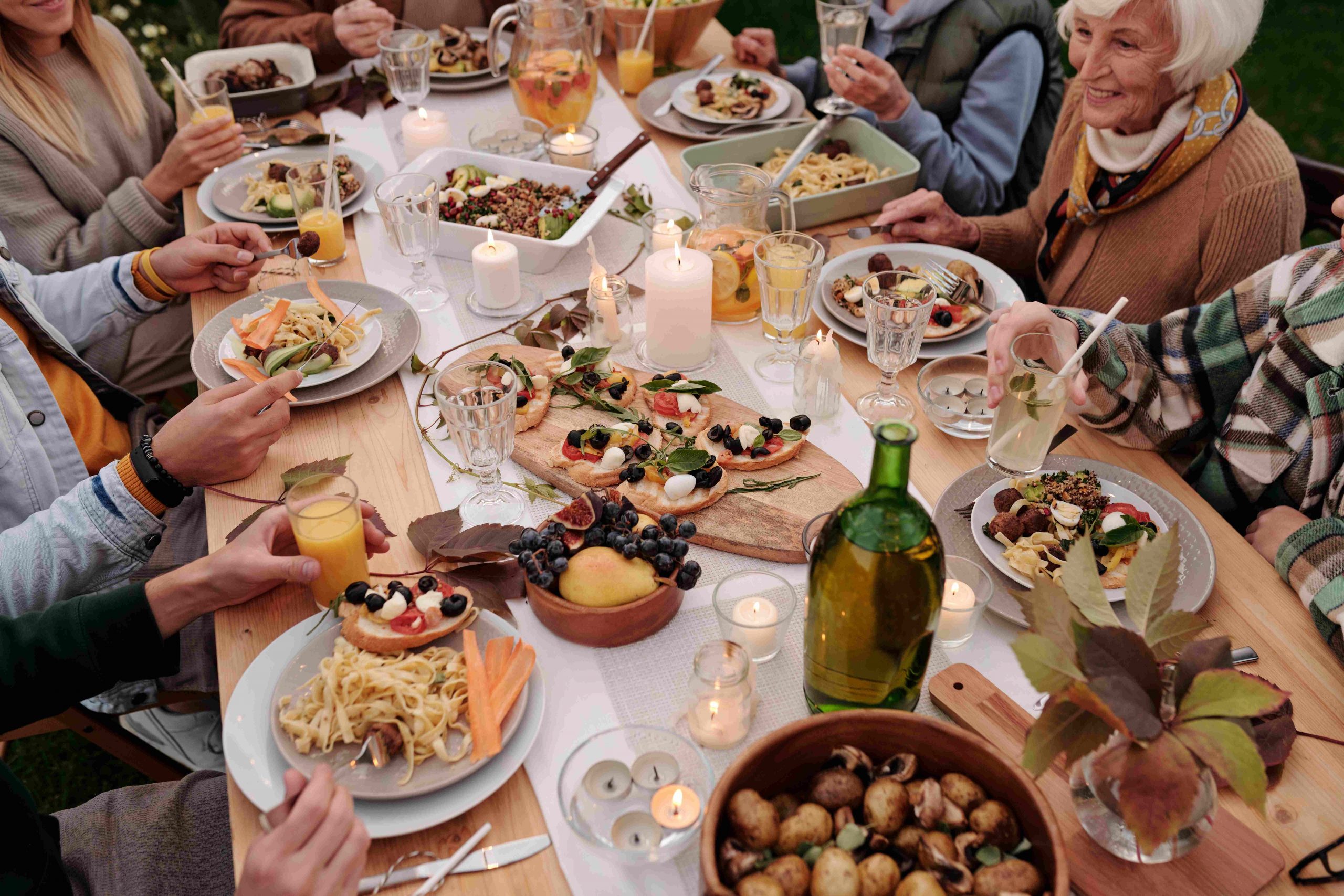 Family Sitting around having a big meal together outdoors.