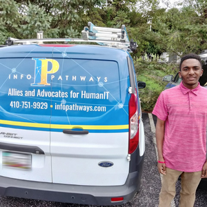 Young man smiling next to company vehicle