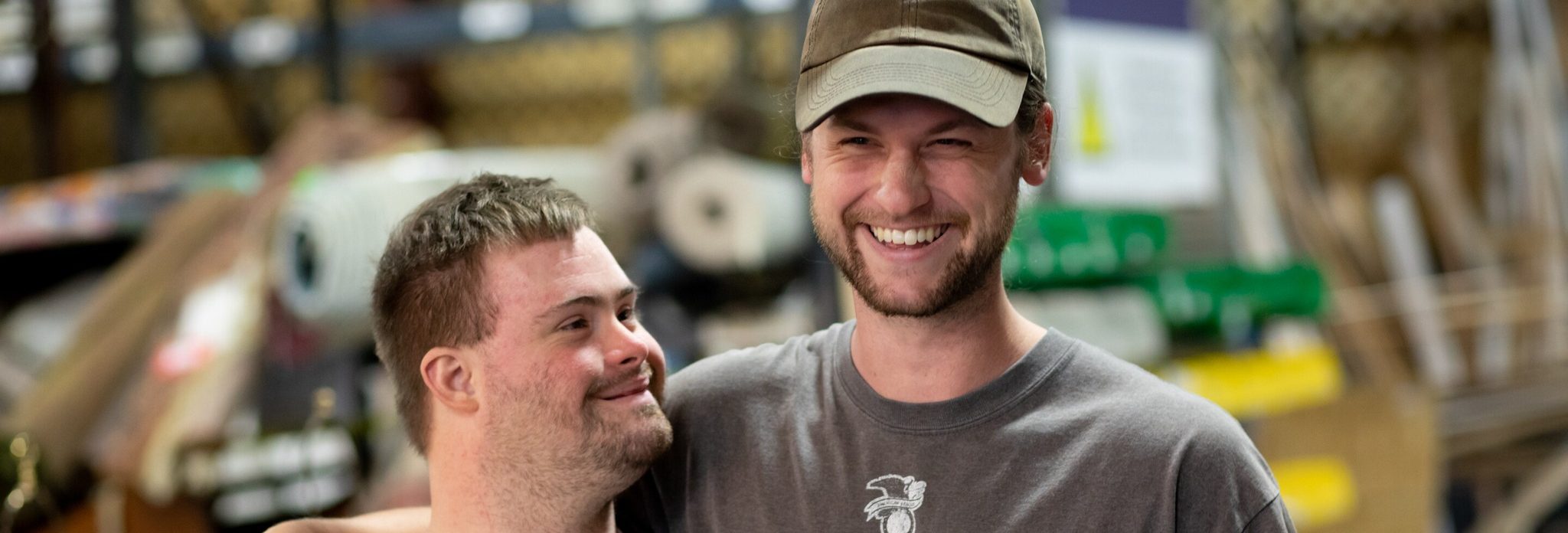 A young man, who is a DSP, has his arm around another young man, who he supports.