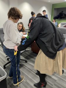 A student measuring the leg of a woman. 