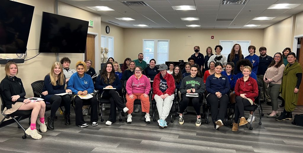 A large group of people in a classroom.