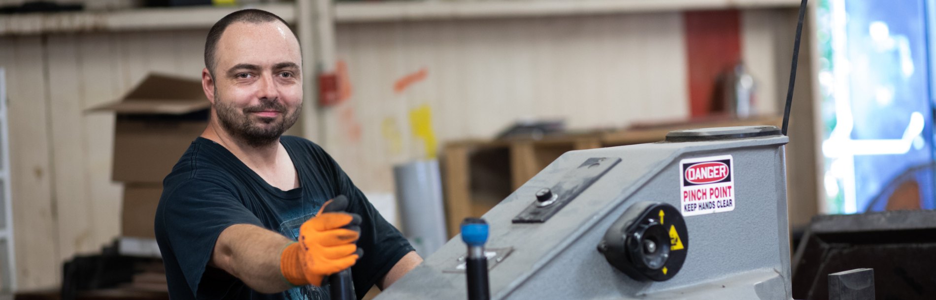 Man working on a machine smiling at the camera.