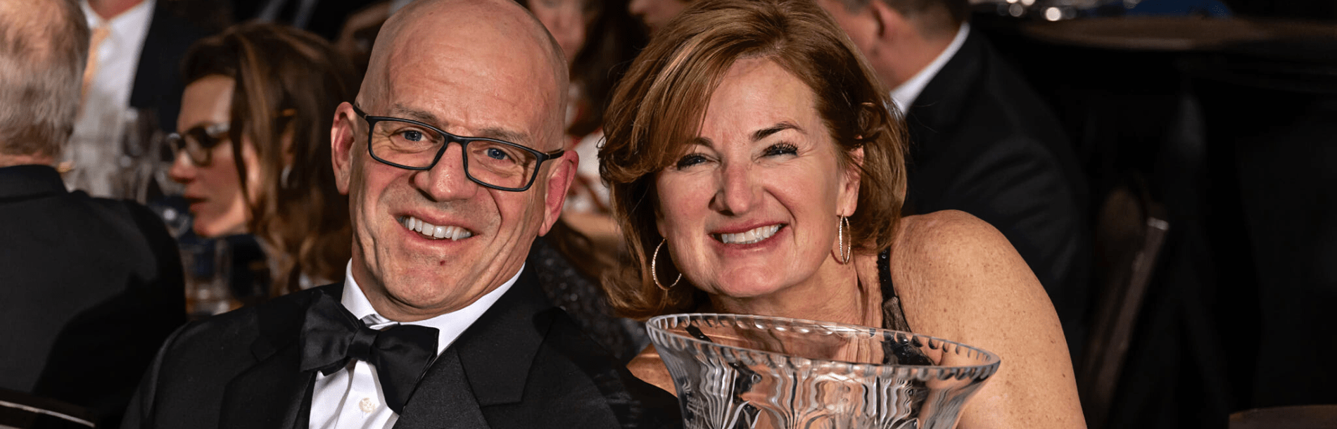 A man and a woman smiling together at a formal event.