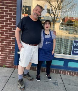 A boss with his employee in front of the bakery. 