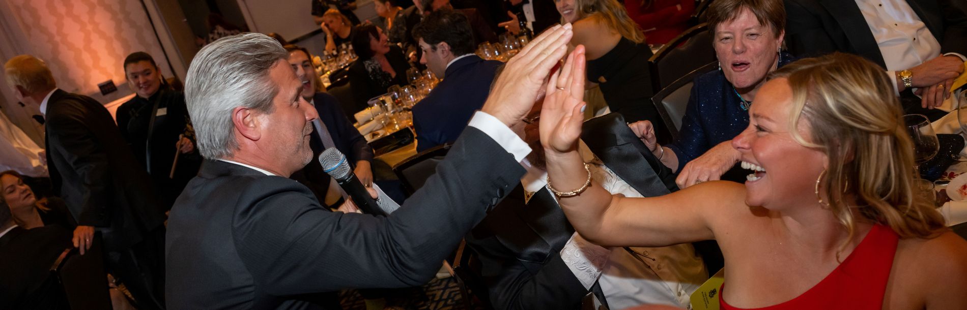 A man and woman high-fiving at gala.