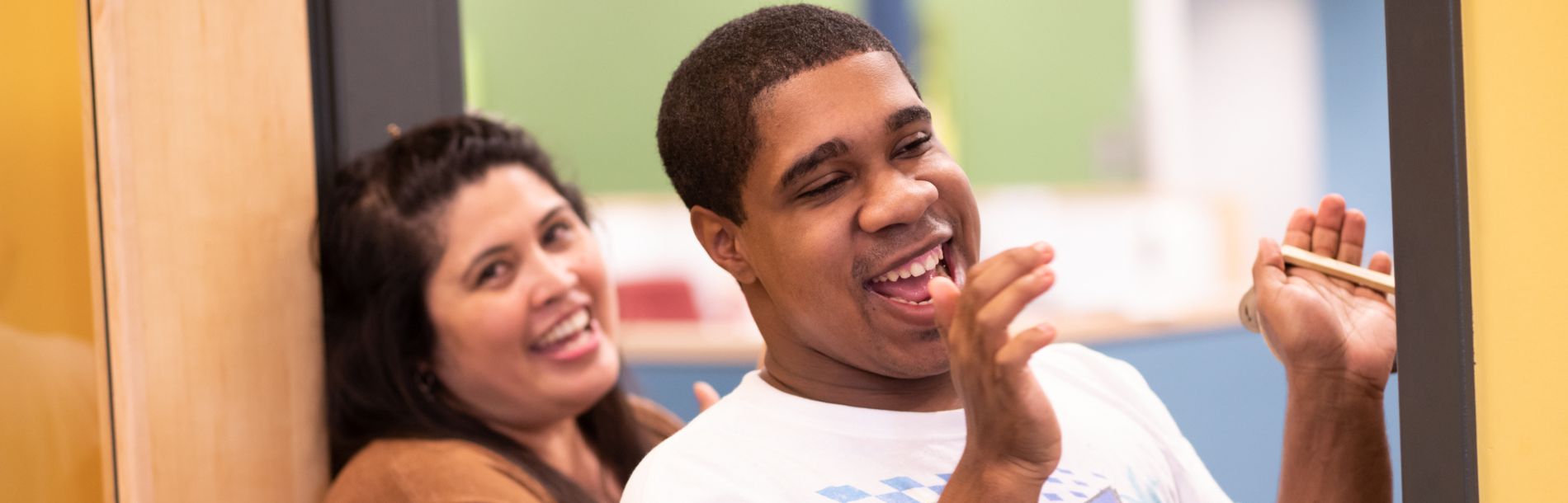 A woman and a man smiling and clapping.