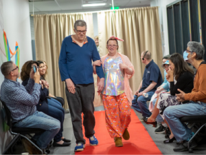 A man and a woman walking down the runway of a fashion show.