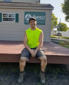 A man sitting on deck in front of his place of employment.