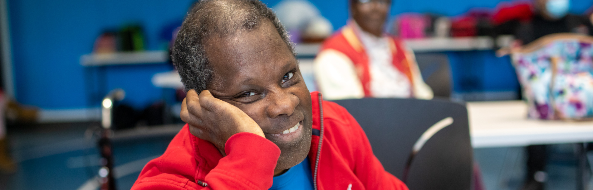 A man leaning his head on his hand and smiling.