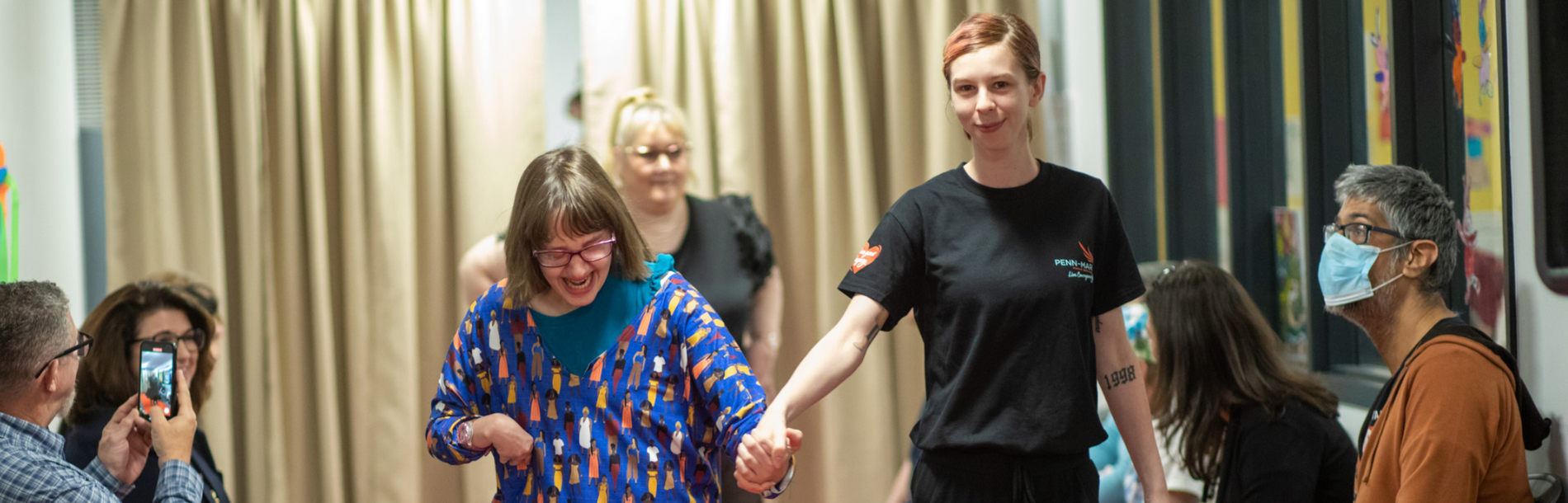 Two women holding eachothers hands.