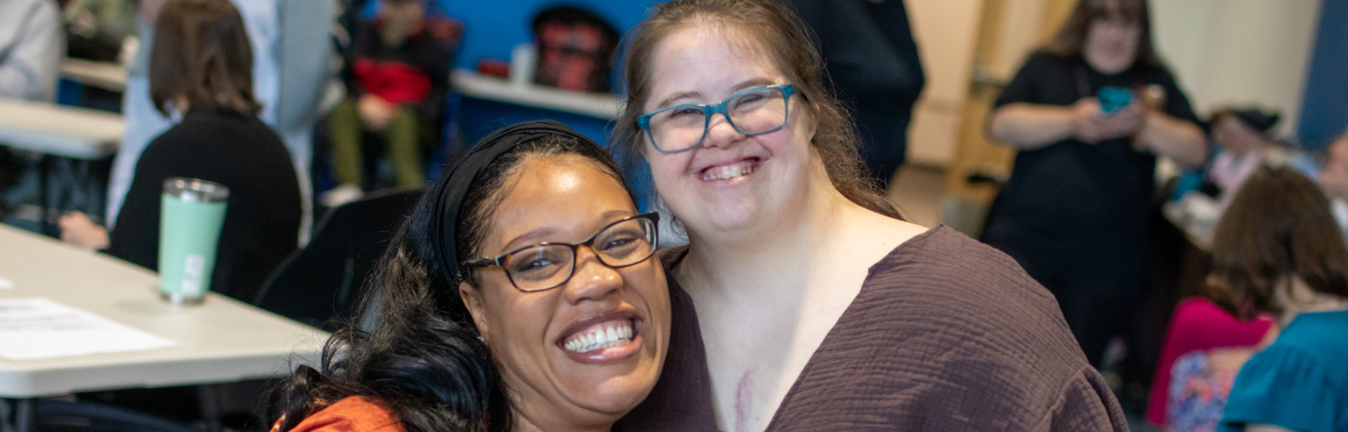 Two women hugging and smiling.