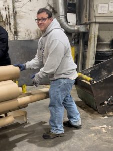 A man at work loading a tube onto the bailer.