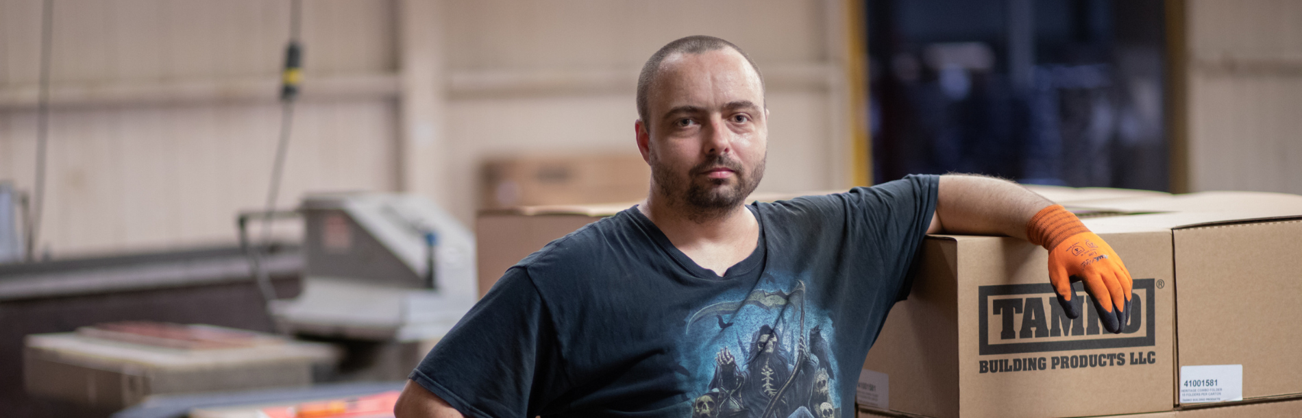 A man poses with materials at work.