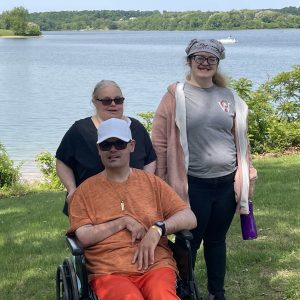 A group of individuals standing in front of a lake together.