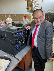 Jay standing in front of a speaker.