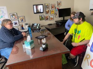 Tyler sitting at a desk talking to a senator. 