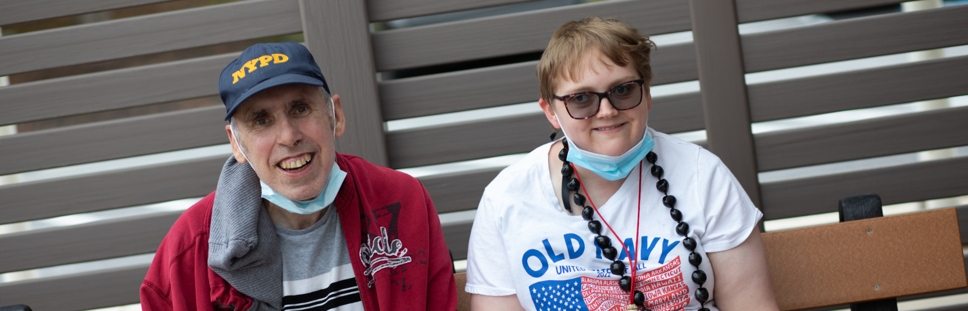 A man and woman sitting on a bench together smiling.