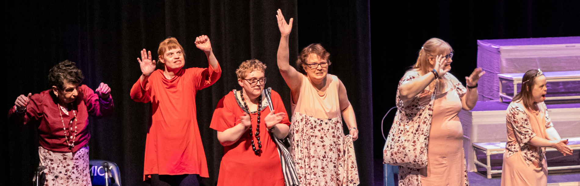 6 women stand side by side celebrating.