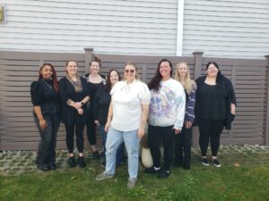 8 graduates of the professional development program standing in a line outside.