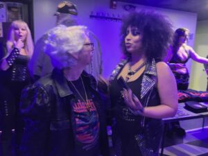 Rita sings and dances on stage with the lead singer.