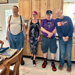 Kimberly Palmer stands next to the three people she supports.