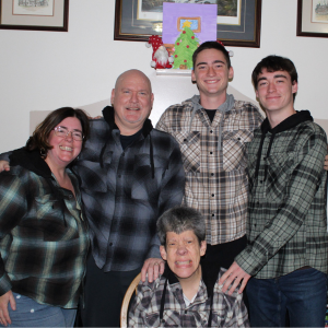 Karen Cunningham stands with her husband and two sons, while Brenda sits on a chair in front of them.