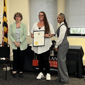 Betty poses at the award ceremony with her certificate.