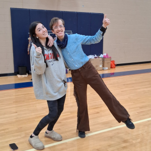 A Jemicy student designer and a Penn-Mar model pose together. The Penn-Mar model is dressed in Western-style clothing for the Fashion Show.