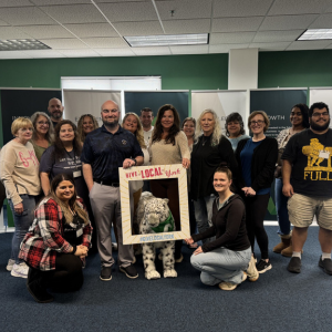 The Nexterus team holds a cardboard cutout Give Local York frame.
